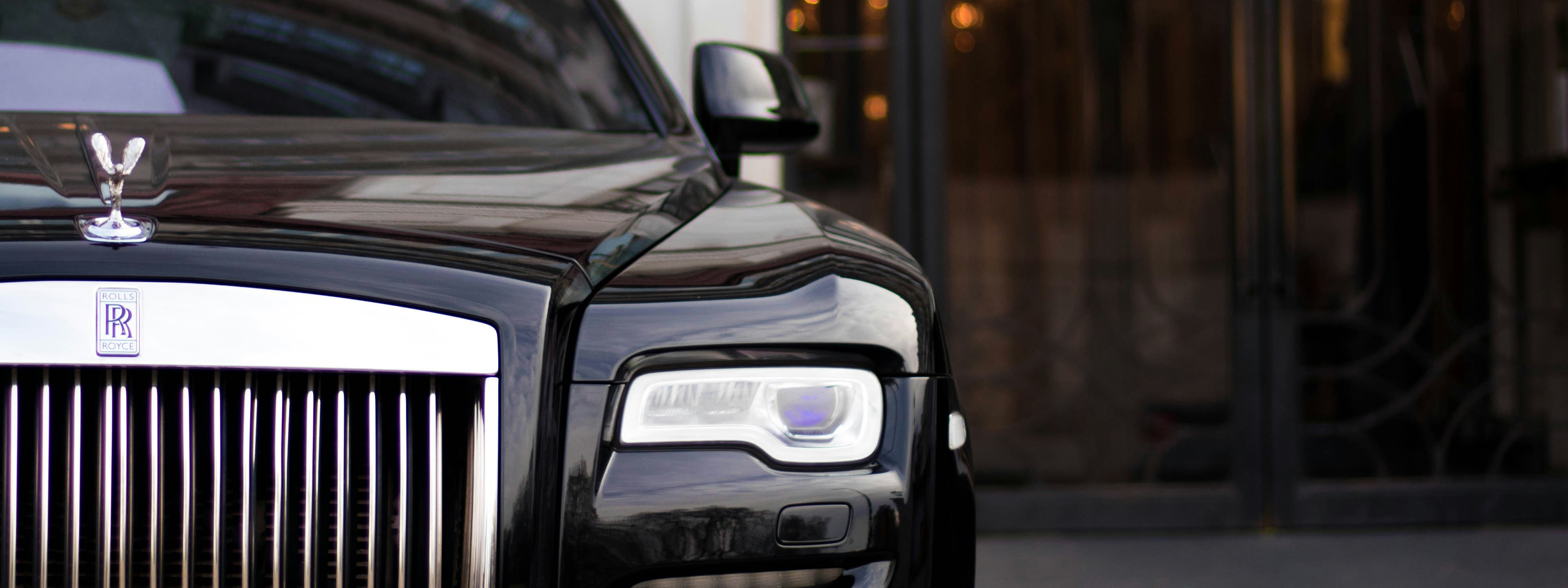 Front of a Rolls Royce car outside building